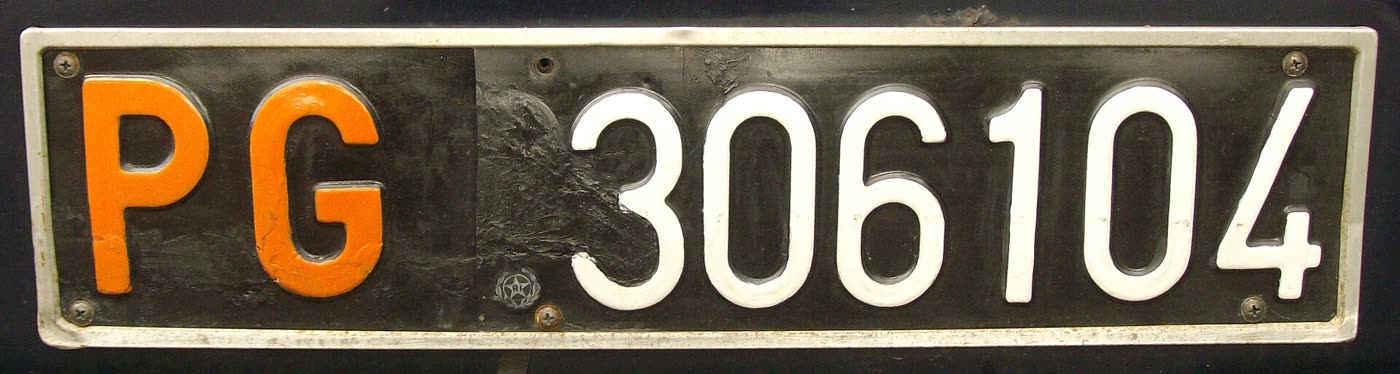 Targa nera con PG in arancione e 306104 in bianco